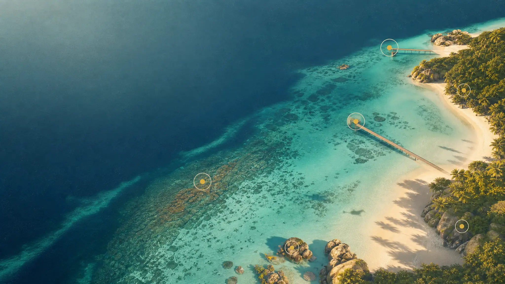 Baie vue du ciel, des repères circulaires posés sur le ponton, le récif et la plage.